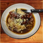 Bangers and Mash - Two Irish banger sausages with colcannon mashed potatoes in a rich onion gravy.
