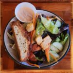 Green Salad - Green Salad of mixed romaine lettuce, shredded carrot, sliced tomato, English cucumbers, and croutons, and dressing on the side.