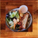 Side Green Salad - Green Salad of mixed romaine lettuce, shredded carrot, sliced tomato, English cucumbers, and croutons, and dressing on the side.